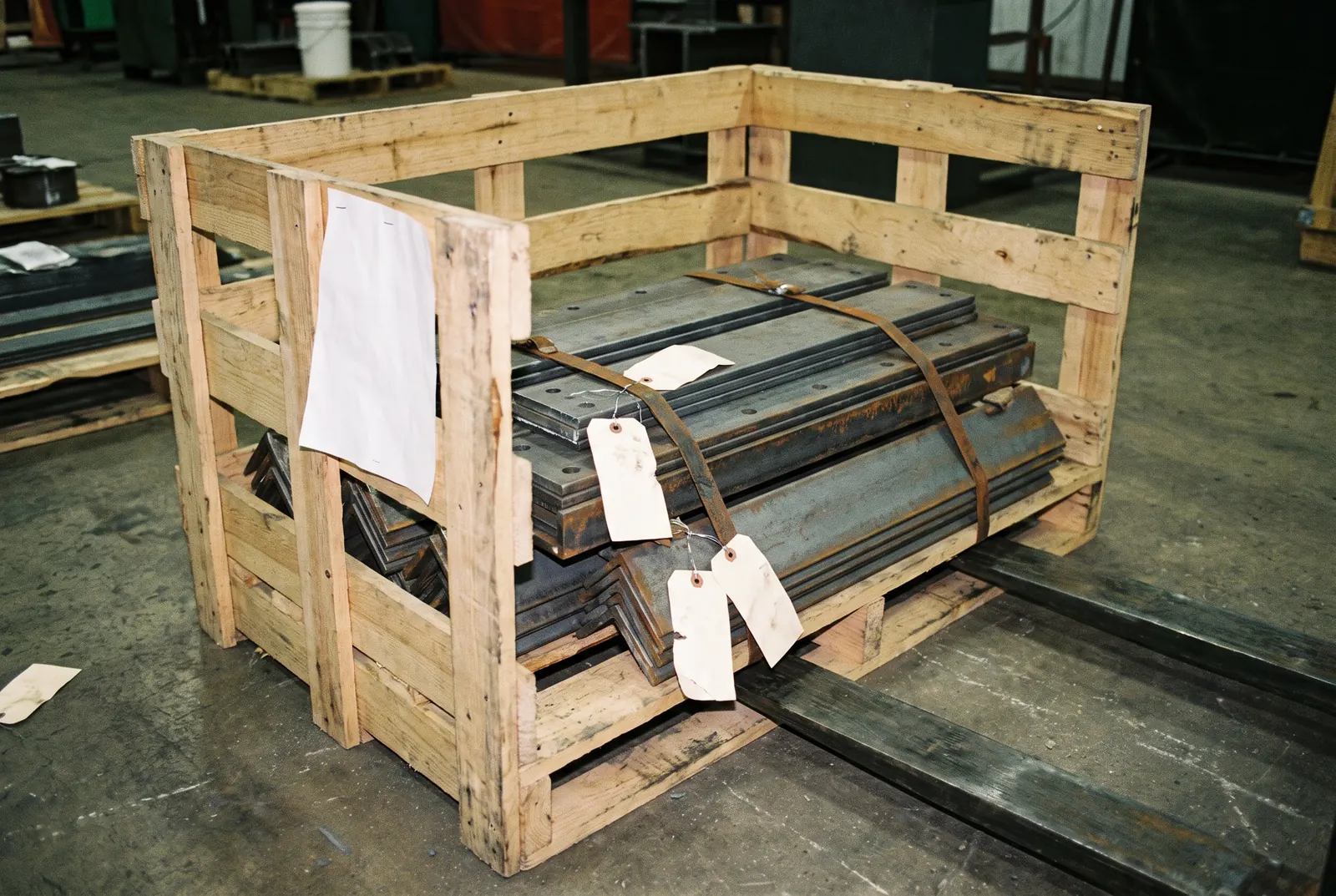 Plaques et cornières d'acier cerclées dans une caisse en bois, prêtes à l'expédition pour une mise à niveau de tour